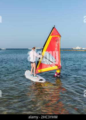 Hurghada, Ägypten - 01. Juni 2021: Der Mensch beginnt Windsurfen zu lernen und erhält eine Lektion von einem männlichen Lehrer in Makadi Bay, die eine von Ägypten schön ist Stockfoto