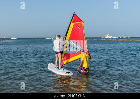 Hurghada, Ägypten - 01. Juni 2021: Der Mensch beginnt Windsurfen zu lernen und erhält eine Lektion von einem männlichen Lehrer in Makadi Bay, die eine von Ägypten schön ist Stockfoto