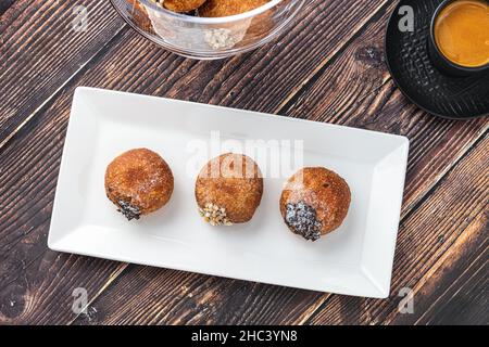 Bombolon oder Bomboloni ist ein italienisches gefülltes Donut- und Snackfutter. Deutsche Krapfen - Krapfen oder berliner - gefüllt mit Marmelade und Schokolade Stockfoto