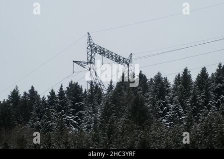 Hochspannungs-Mast in der schneebedeckten Berglandschaft der Vogesen in Frankreich Stockfoto