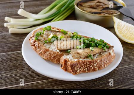 Sandwiches mit geräuchertem Sprotte, Butter und grünen Zwiebeln. Dänische Küche. Stockfoto