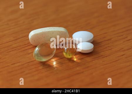 Pillen Vitamine auf einem Holzbrett Alle diese Vitamintabletten für Frauen. Vitamine, Pillen Und Tabletten Stockfoto