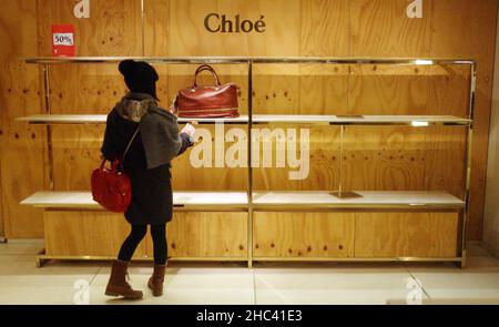 Aktenfoto vom 26/12/2009 von einer Frau, die die letzte Handtasche in der Chloe-Abteilung in Selfridges in der Oxford Street, London, ansah, als der Verkauf am zweiten Weihnachtsfeiertag beginnt. Die Familie Weston hat die 1908 von Harry Gordon Selfridge gegründete Luxuseinzelhandelsgruppe Selfridges an den Einzelhändler Signa Holding und die Immobiliengesellschaft Central Group verkauft. Ausgabedatum: Freitag, 24. Dezember 2021. Stockfoto