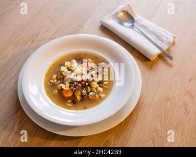 Minestrone italienische Gemüsesuppe in einem eleganten weißen Teller mit Löffel Stockfoto