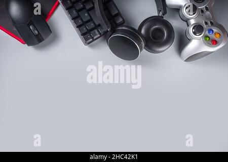 Konzept für Gaming- und Gamer-Geräte. Gamer Arbeitstisch Raum Hintergrund, Draufsicht. Tastatur, Maus, Gamepad Joystick, Mauspad und Kopfhörer. Auf grau ta Stockfoto