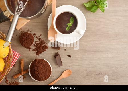 Heiße Schokolade Rezept Zubereitung mit Minze, Zitrone und Zimt auf Küchentisch. Draufsicht. Stockfoto