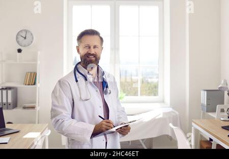Porträt eines lächelnden männlichen Arztes in weißer medizinischer Uniform Stockfoto