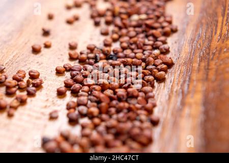 Rote Quinoa-Samen auf Holzhintergrund. Makro. Rustikale Holzschale Stockfoto