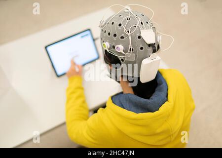 Person unterziehen ein Elektroenzephalogramm mit einem EEG Kappe, ihr Gehirn elektrische Aktivität zu scannen Stockfoto