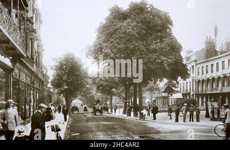 Cheltenham Promenade vor einem Jahrhundert (1901) in der Nähe von Cavendish House mit Pferden und Karren und Menschen auf Fahrrädern Gloucestershire UK Stockfoto