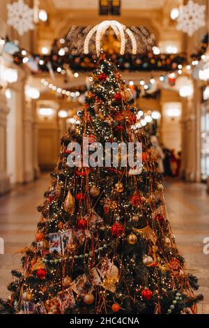 Vintage Retro-Weihnachtsspielzeug und Girlanden hängen am festlichen Weihnachtsbaum. Neujahrsstimmung, märchenhafte Details und interessante Retro-Dekorationen Stockfoto