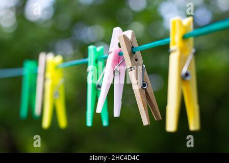 Farbige Kunststoff- und Holzklammern an der Wäscheleine. Kleidung Pins im Sommer Tag. Stockfoto