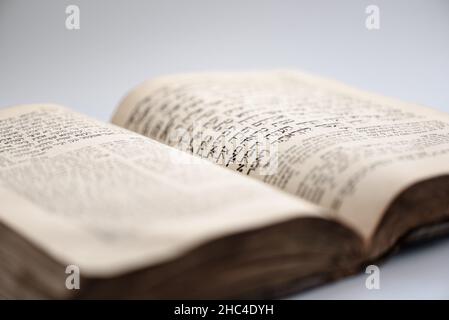 Nahaufnahme eines abgenutzten schäbigen jüdischen heiligen Buches. Öffne die Seite von Tora. Selektiver Fokus Stockfoto
