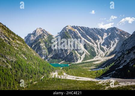 Luftaufnahme des pragser wildsee in der Ferne mit Wald und dolomitenbergen an einem sonnigen Tag Stockfoto