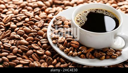 Schwarzer Kaffee in weißer Keramik-Tasse auf Kaffeebohnen Hintergrund Stockfoto