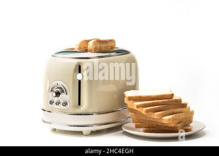 Retro-Toaster und geröstete Brotscheiben und mit Scheiben Toastbrot auf einem Teller isoliert auf weißem Hintergrund Stockfoto