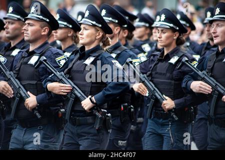Ukraine, Kiew - 18. August 2021: Selektiver Fokus. Ukrainischer Polizist mit einem Maschinengewehr. Ein Mann und eine Frau in Uniform. Die Polizei marschiert in die Parade ein. Automatisches Gewehr. Armee Stockfoto