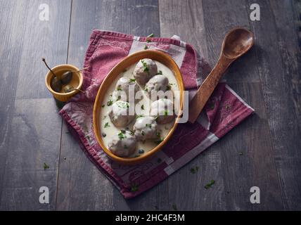 Draufsicht auf Konigsberger Klopse Fleischbällchen in cremig weißer Sauce auf einer Holzoberfläche Stockfoto