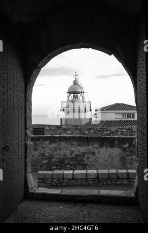 Der Leuchtturm von Peniscola vom Balkon und dem Schloss in der Altstadt von Peniscola, Castellon, Spanien. September 2021. Vertikale Aufnahme. Stockfoto