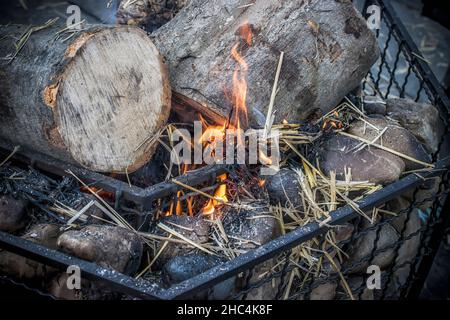 Eine Nahaufnahme von brennenden Holzstämmen und Stroh Stockfoto