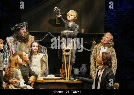 Hinten links: James Head (Ghost of Christmas Present) Mitte: Laurence Belcher (Tiny Tim) hinten rechts: Tommy Steele (Ebenezer Scrooge) mit der Cratchit-Familie in SCROOGE im London Palladium, London W1 08/11/2005 Basierend auf 'A Christmas Carol' von Charles Dickens Buch, Musik & Texte: Leslie Bricusse Design: Paul Farnsworth Beleuchtung: Nick Richings Choreographie: Lisa Kent Illusions: Paul Kieve Regie: Bob Tomson Stockfoto