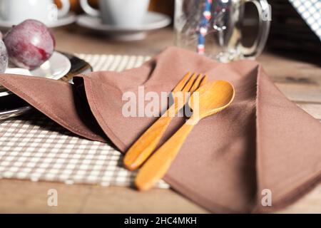 Holzlöffel und Gabel auf die Serviette gelegt. Legen Sie den Tisch fest Stockfoto