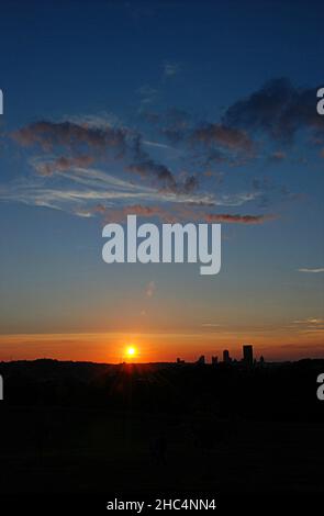 Vertikale Aufnahme des wunderschönen Sonnenuntergangs über einer Landschaft mit Gebäuden in Pittsburgh, PA Stockfoto