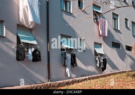 Kleidung, Handtücher und Bettwäsche hängen zum Trocknen aus dem Fenster (Pesaro, Italien, Europa) Stockfoto