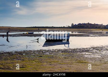 Blick auf den Strand von La Gaviota bei Ebbe, wo einige Fischer Meeresfrüchte abholen. Cristina Island, Huelva, Andalusien, Spanien Stockfoto