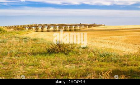 Blick auf die Holzbrücke, die den Zugang zum Strand ermöglicht, wenn er auf See ist. Isla Cristina, Andalusien, Spanien Stockfoto