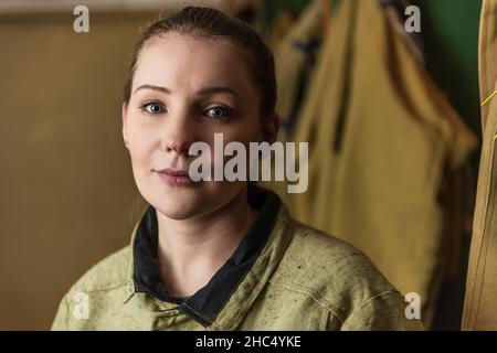 Brunette Schweißer Blick auf die Kamera in der Fabrik Stockfoto