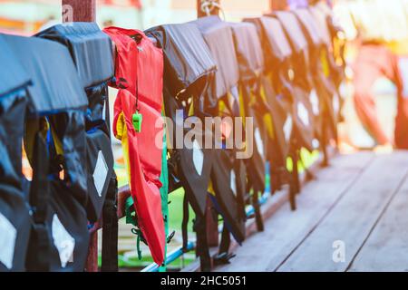 Eine grüne Pfeife mit roter Lebensjacke, die am Geländer um den Gehweg hängt, damit die Passagiere sicher an den Docks sind. Stockfoto