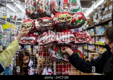 Hongkong, China. 24th Dez 2021. In einem Straßenladen in Hongkong werden Käufer gesehen, wie sie Weihnachtsschmuck und -Kostüme kaufen. Kredit: SOPA Images Limited/Alamy Live Nachrichten Stockfoto