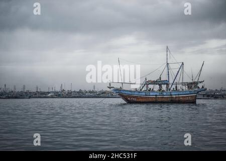 Graustufenaufnahme eines alten Schiffes, das unter dunklen Sturmwolken im Meer segelt, Stockfoto