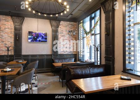 Minsk, Weißrussland - 20. Dezember 2021: Café-Interieur mit großen Panoramafenstern Stockfoto