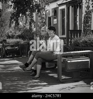 18th. Juli 2020, Russland, Altay, zwei Frauen rauchen und kommunizieren auf der Bank Stockfoto