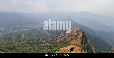 Blick auf die Berge und das Tal der westlichen Ghats gegen den blauen Himmel von Elphinstone Point, Mahabaleshwar, Mumbai, Maharashtra. Ausgangspunkt von Savitri riv Stockfoto