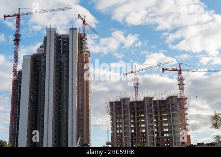 Low-Angle-Aufnahme von zwei Wolkenkratzern im Bau mit roten Kränen. Stockfoto