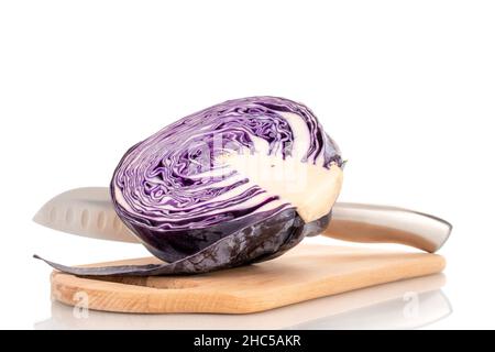 Eine Hälfte frischen Rotkohls auf einem Holztablett mit einem Metallmesser, Nahaufnahme, isoliert auf Weiß. Stockfoto