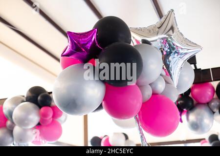 Bunte Luftballons, rosa, weiß, rot, Luftschlangen. Stockfoto