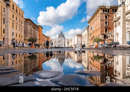 Rom, Italien - 6. November 2018: Die Menschen gehen entlang der Straße, die zur piazza San Pietro führt, zum Vatikan. Der blaue Himmel spiegelt sich im Wasser Stockfoto