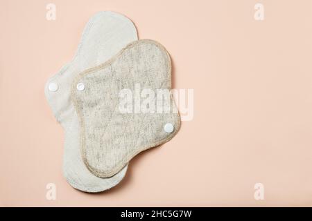 Wiederverwendbare Menstruationskissen mit Nullabfall unterschiedlicher Größe und Textil auf hellbeigem Hintergrund Stockfoto