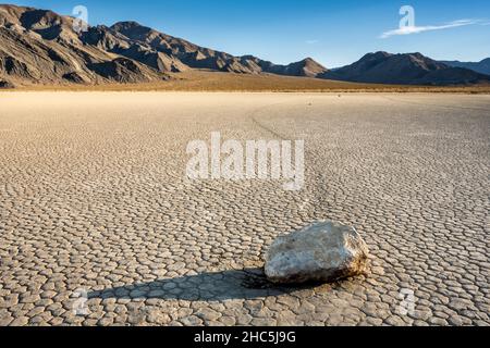 Long Shadow fällt über Einen Segelstein mit seinem Pfad, der über die Rennstrecke im Death Valley verblasst Stockfoto