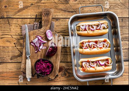 Vegan Vegetarische Hotdogs mit Zwiebeln und fleischloser Wurst. Holzhintergrund. Draufsicht Stockfoto