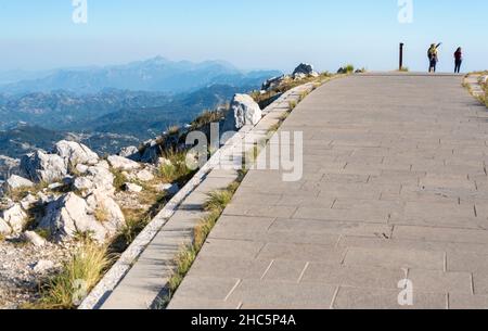 Lovcen Nationalpark, Montenegro-September 14 2019: Bei Sonnenuntergang, eine Gruppe von jungen Wanderern, auf dem Gipfel des Mount Lovcen, beginnen, den Weg A hinunter zu wandern Stockfoto