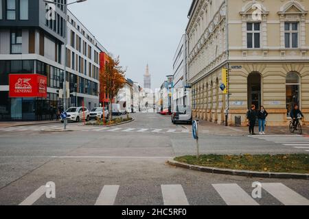 Nebliger Herbsttag in Klagenfurt, Österreich mit Autos auf der Straße geparkt Stockfoto