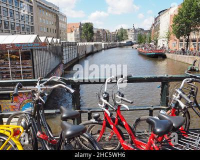 Blick auf Fahrräder, die auf der Brücke in Amsterdam geparkt sind Stockfoto