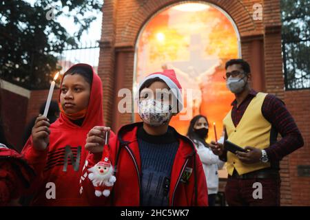 Neu-Delhi, Indien. 24th Dez 2021. Kinder, die am Vorabend der Weihnachtszeit vor der Kirche des Heiligen Herzens gesehen werden, als die Kirchen sich schließen, um die Ausbreitung von Covid-19 zu vorbeugen. Die Regierung von Delhi kündigte ein Verbot von kulturellen Veranstaltungen und Versammlungen von Gemeinden an, um das bevorstehende Weihnachts- und Neujahrsfest zu feiern. Kredit: SOPA Images Limited/Alamy Live Nachrichten Stockfoto