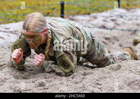 Grafenwoehr, Bayern, Deutschland. 14th Dez 2021. US Army Capt. Valerie Nostrant, zugewiesen zu 1st Squadron, 91st Cavalry Regiment, 173rd Airborne Brigade, tief kriecht unter Stacheldraht während des Hinderniskurses Teil einer Spornfahrt auf dem 7th Army Training Command's Grafenwoehr Training Area, Deutschland, 14. Dezember 2021. Der Zweck dieser Spornfahrt ist es, neue Fallschirmjäger in die Luftgetragene Kavallerie zu integrieren und innerhalb der Staffel einen Esprit de Corps aufzubauen, der sich auf das Erbe der Kavallerie konzentriert. Kredit: U.S. Army/ZUMA Press Wire Service/ZUMAPRESS.com/Alamy Live Nachrichten Stockfoto