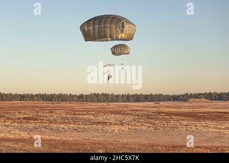 Fort Bragg, North Carolina, USA. 14th Dez 2021. Fallschirmjäger der US-Armee, die der Airborne Division 82nd zugewiesen sind, bereiten sich auf die Landung während All American Presents from Fallschirmjäger (A2P2) auf Fort Bragg, N.C., 14. Dezember 2021 vor. A2P2 ist eine jährliche Veranstaltung, bei der Fallschirmjäger die Möglichkeit hatten, ein Spielzeug zu spenden, um zu springen und ausländische Sprungflügel zu verdienen. Kredit: U.S. Army/ZUMA Press Wire Service/ZUMAPRESS.com/Alamy Live Nachrichten Stockfoto